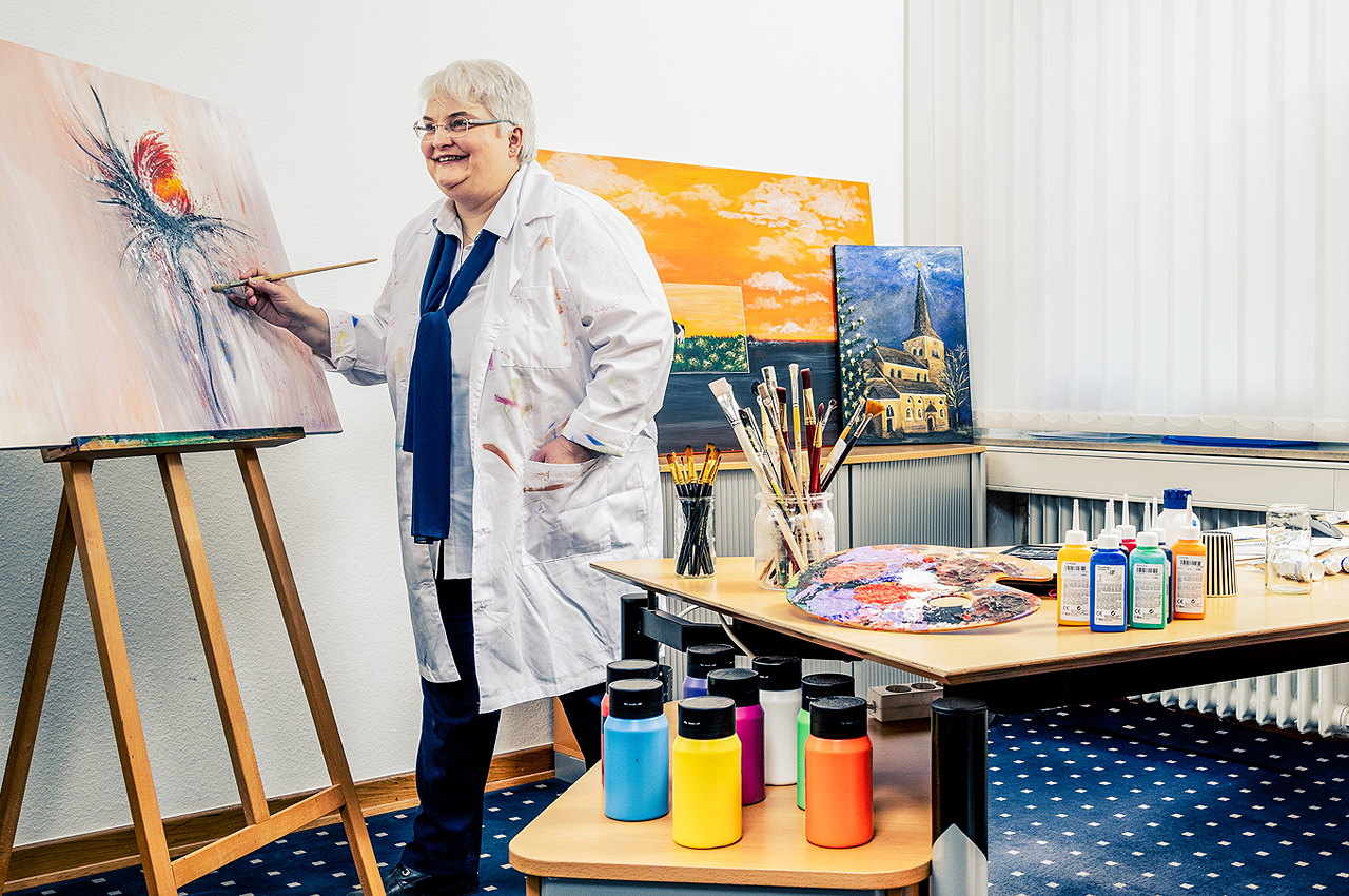 Susanne Scherff, Hobby-Malerin, steht an Staffelei und malt Gemälde.