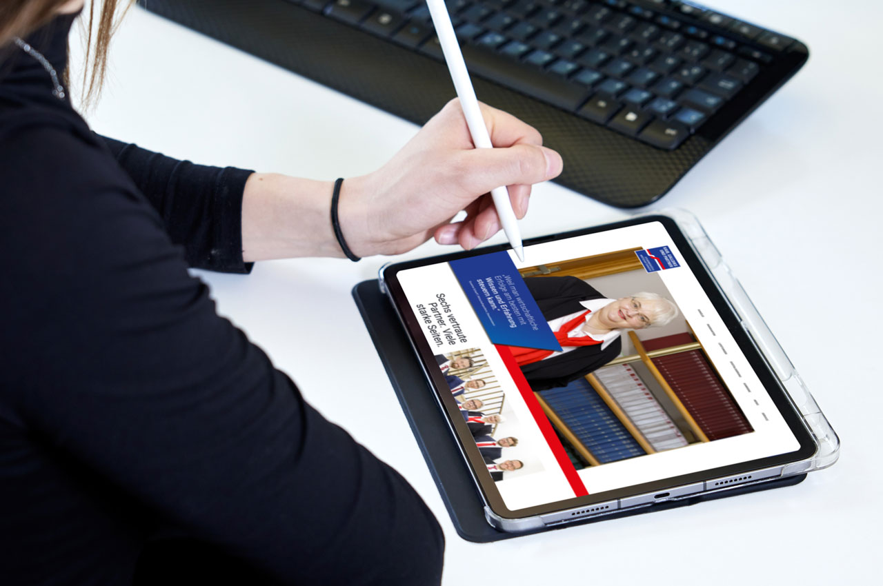 Hand mit Stift bedient Tablet, auf dem die Webseite von Kaib, Galldiks und Partner zu sehen ist.